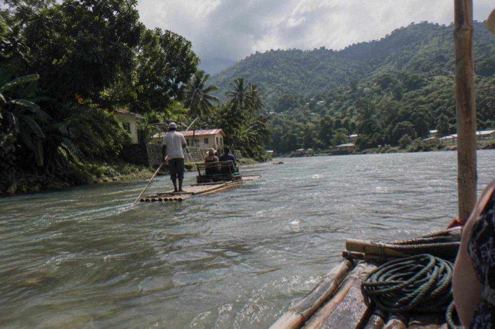 Tree-covered hillsides rising above a wide slow river at midday