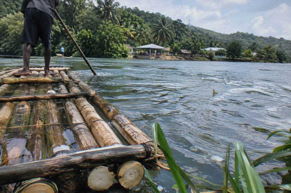 A close view of bamboo poles lashed together forming the deck of a river raft on calm water