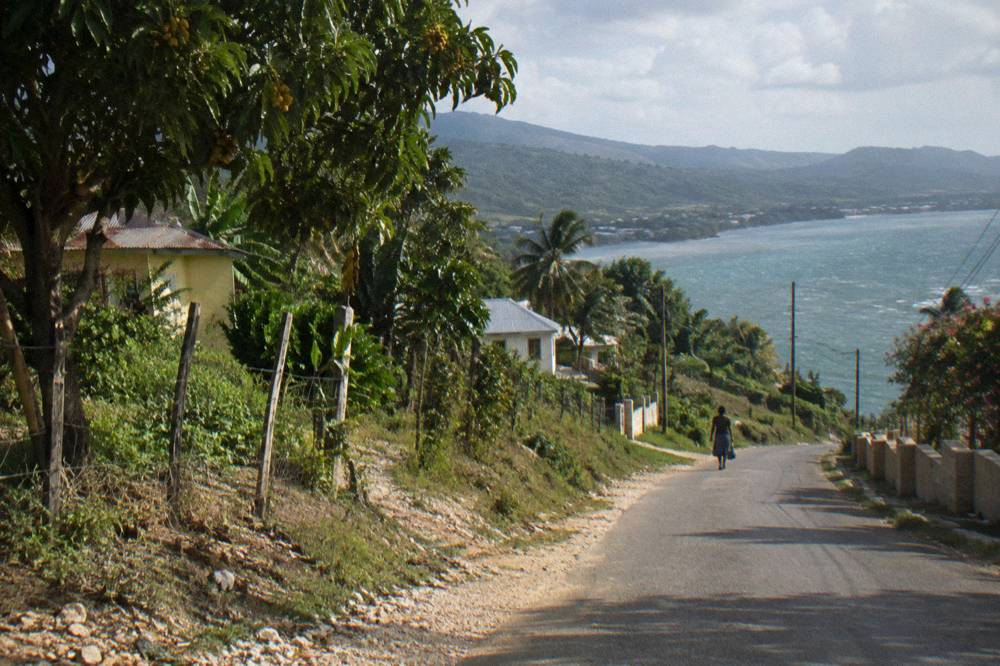 A quiet country road winding through green hills toward a river valley