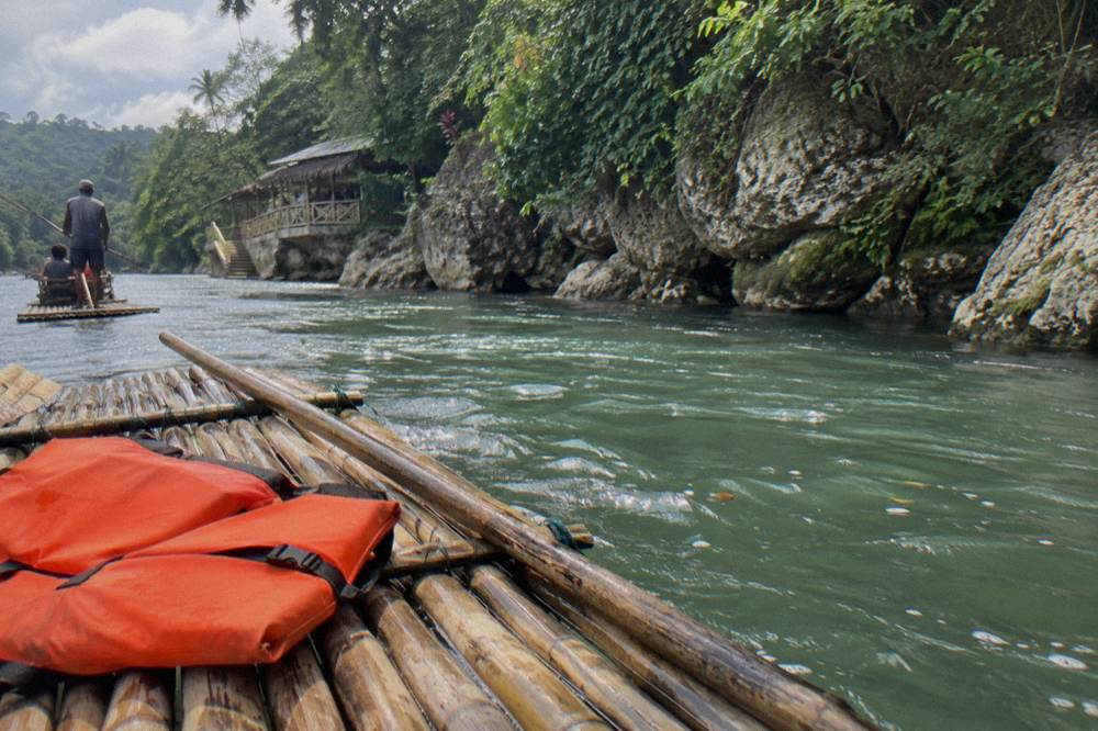 A folded life vest resting on the bamboo slats of a moored raft