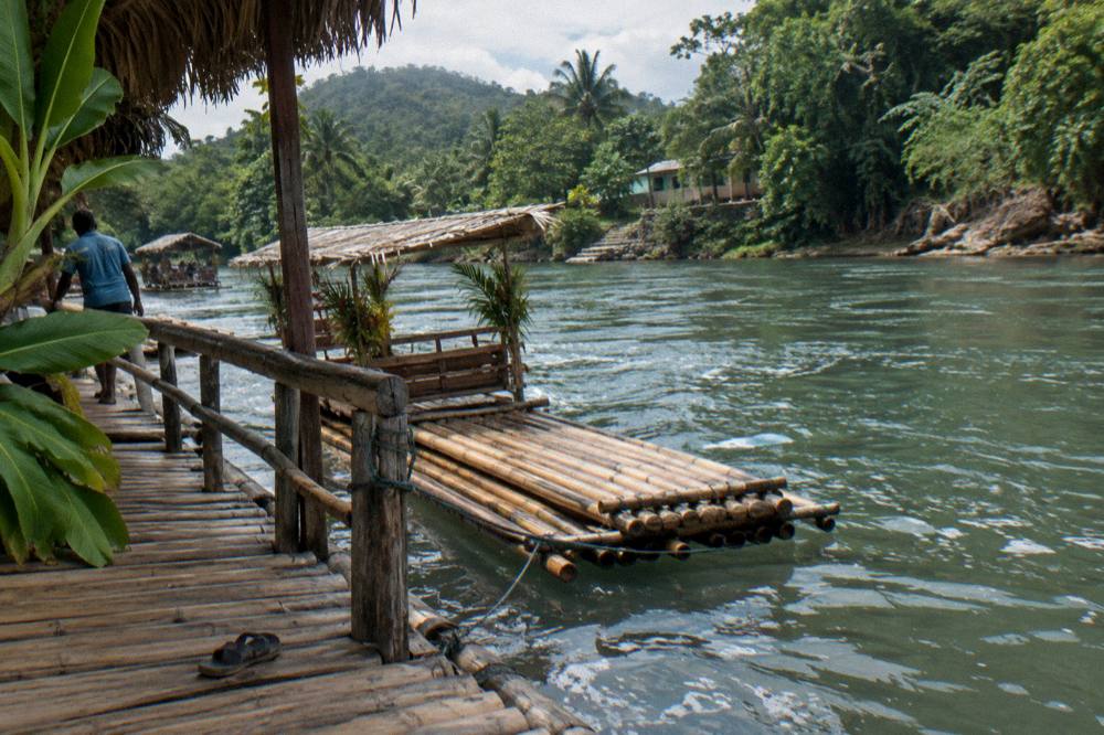 Shaded railing and dry bamboo decking at a quiet river landing point