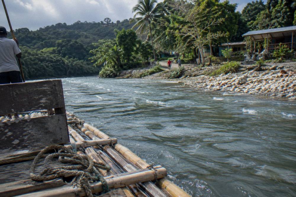 A wooden raft seat and coiled rope on a bamboo raft at the riverbank