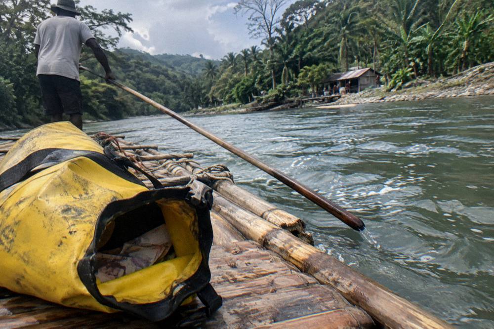 Small denomination banknotes tucked into a dry bag resting on a woven raft mat