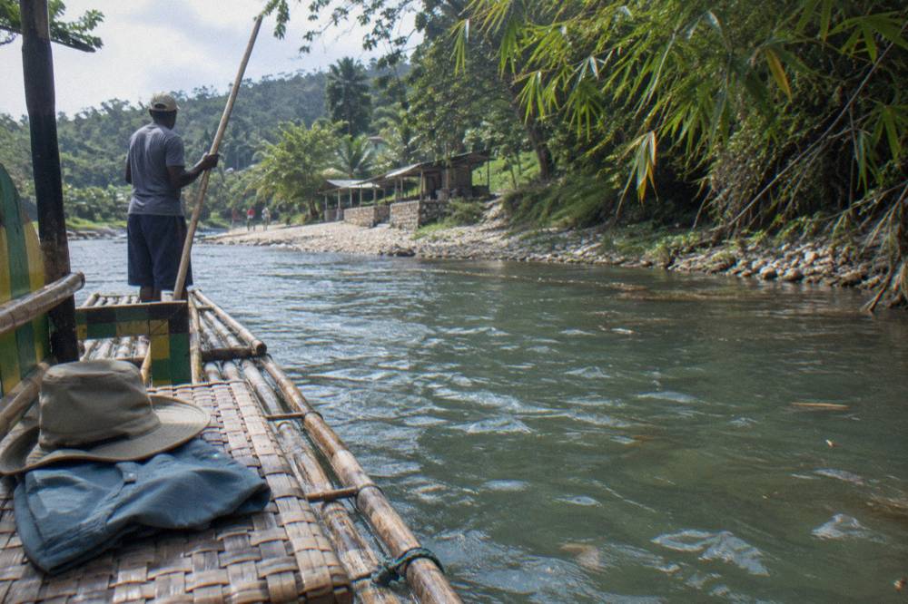 Folded quick-dry clothing and a wide-brimmed hat resting on a riverside bench